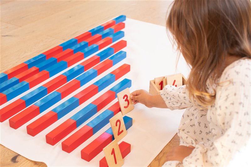 Niña usando el material Montessori de las barras rojas y azules